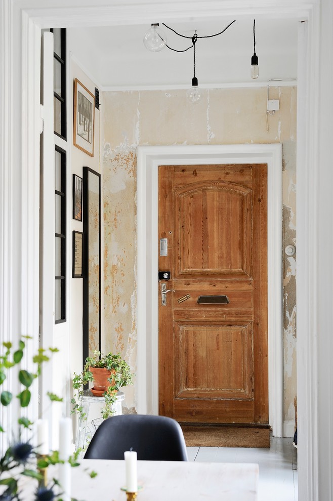Mittelgroßer Shabby-Look Eingang mit Korridor, beiger Wandfarbe, gebeiztem Holzboden, Einzeltür und hellbrauner Holzhaustür in Göteborg