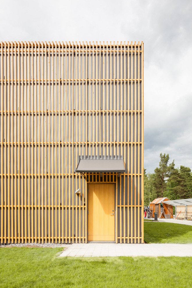 Bild på en mellanstor minimalistisk ingång och ytterdörr, med gula väggar, betonggolv, en enkeldörr och en gul dörr