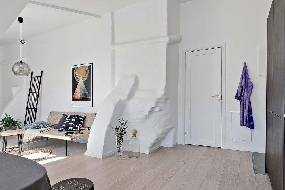 Idéer för att renovera en mellanstor minimalistisk foajé, med vita väggar, ljust trägolv, en enkeldörr och en vit dörr