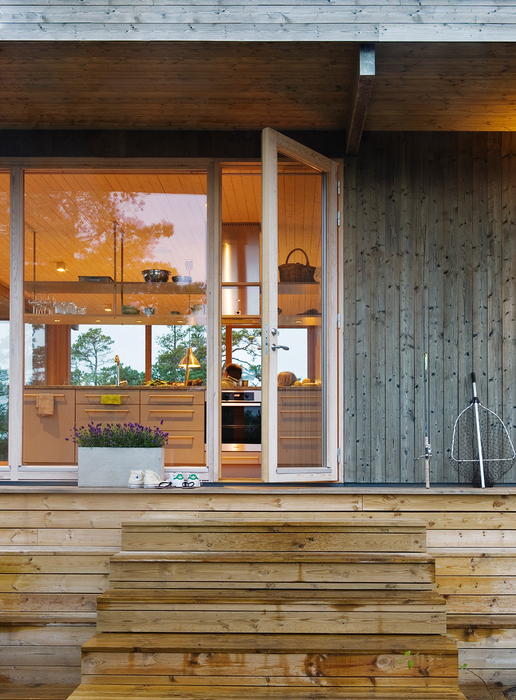 Aménagement d'une petite porte d'entrée scandinave avec un mur marron, un sol en bois brun, une porte simple et une porte en verre.