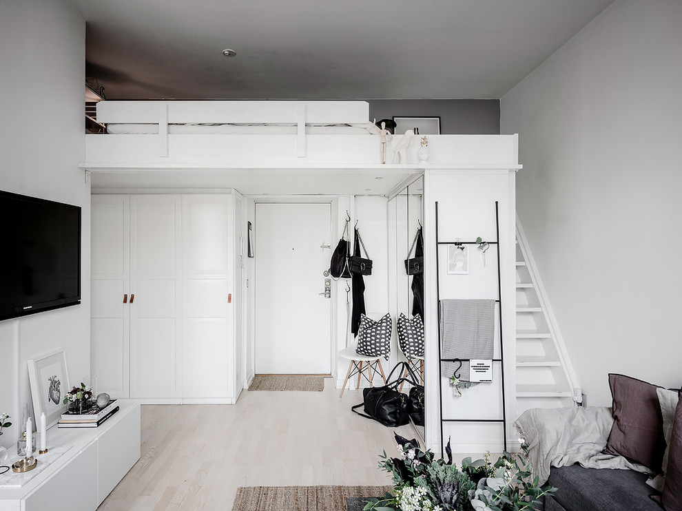 Skandinavisk inredning av en foajé, med grå väggar, ljust trägolv, en enkeldörr, en vit dörr och beiget golv
