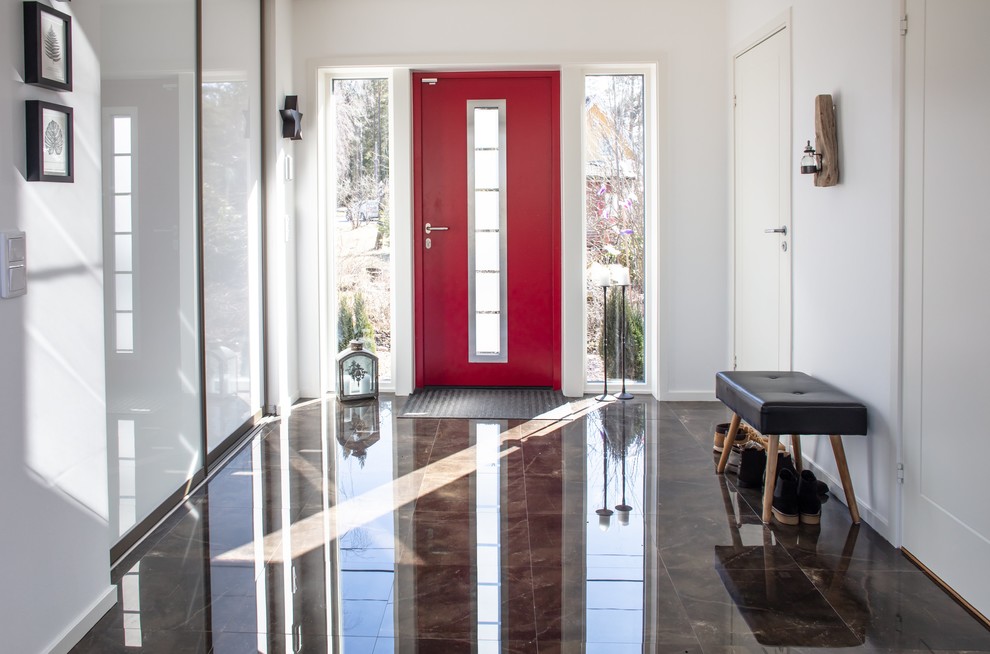 Пример оригинального дизайна: фойе в скандинавском стиле с одностворчатой входной дверью, красной входной дверью и коричневым полом