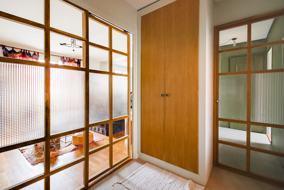 Cette photo montre un petit hall d'entrée éclectique avec un mur vert, une porte coulissante et une porte en bois clair.