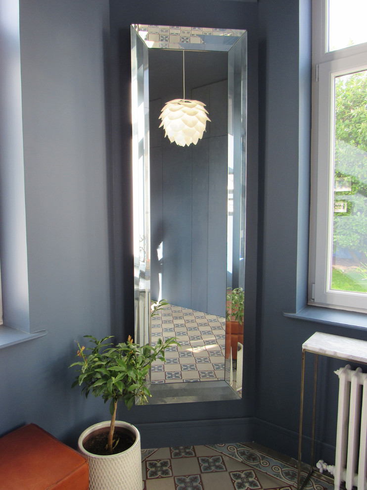 Idee per un grande ingresso minimalista con pareti blu, pavimento con piastrelle in ceramica, una porta singola e una porta bianca