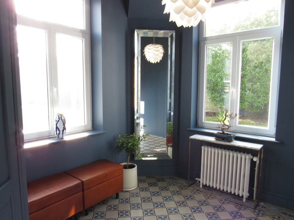 Esempio di un grande ingresso moderno con pareti blu, pavimento con piastrelle in ceramica, una porta singola e una porta bianca