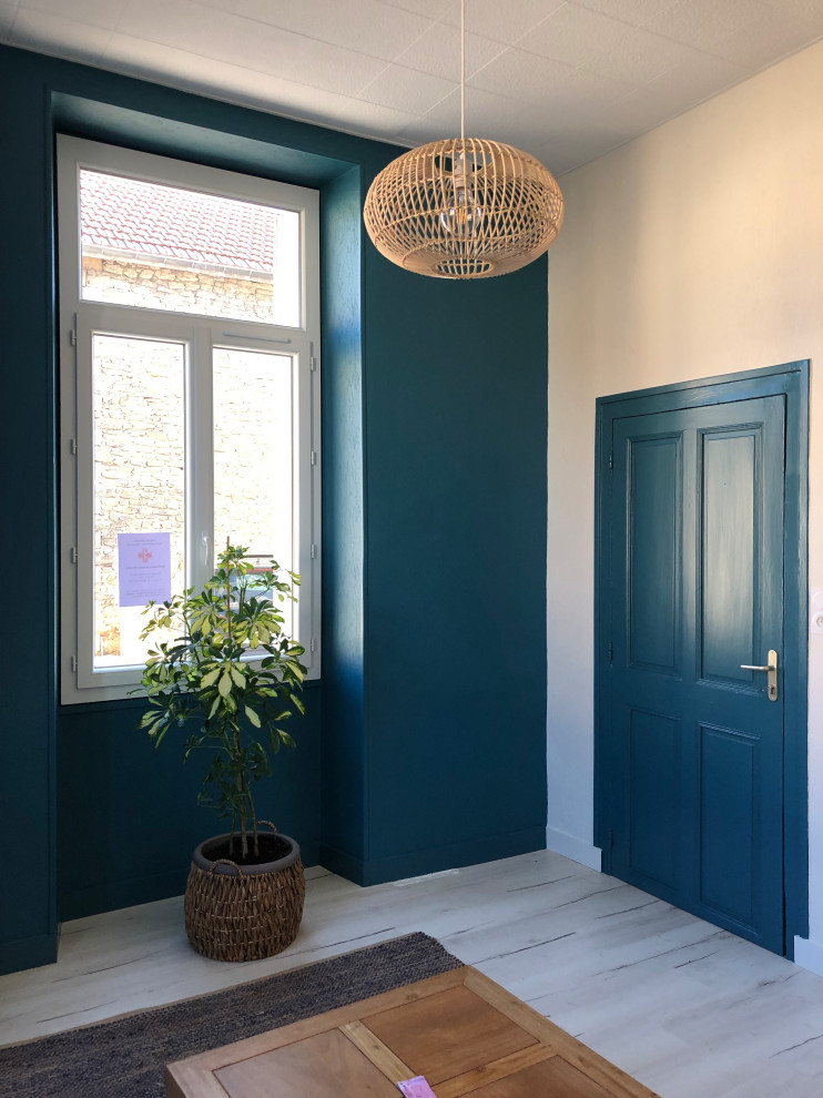 Свежая идея для дизайна: маленькое фойе в современном стиле с синими стенами, полом из ламината, синей входной дверью и белым полом для на участке и в саду - отличное фото интерьера