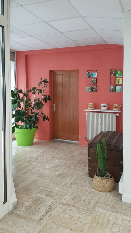 Esempio di un ingresso con vestibolo tropicale di medie dimensioni con pareti arancioni, pavimento in travertino, una porta a due ante, una porta bianca e pavimento beige