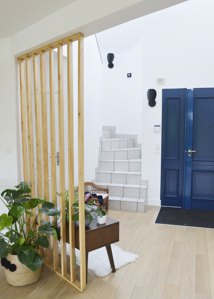 Inspiration pour un hall d'entrée design de taille moyenne avec un mur blanc, parquet clair, une porte simple, une porte en bois brun et un sol beige.