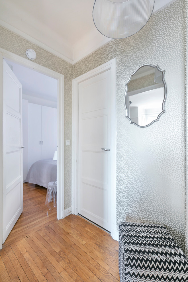 Idee per un piccolo ingresso chic con pareti con effetto metallico, parquet chiaro, una porta singola, una porta bianca e pavimento marrone