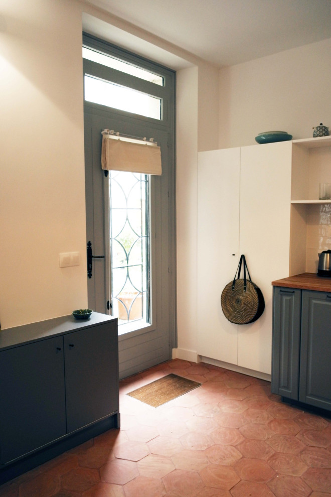 Источник вдохновения для домашнего уюта: фойе среднего размера в стиле неоклассика (современная классика) с белыми стенами, полом из терракотовой плитки, серой входной дверью и красным полом