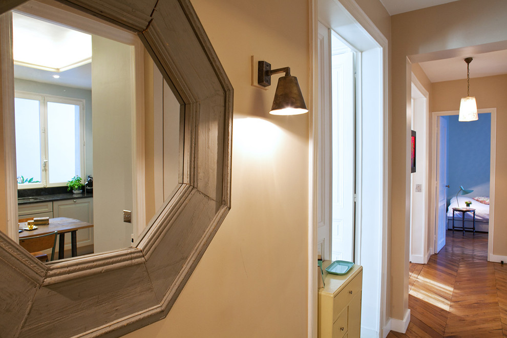 Свежая идея для дизайна: узкая прихожая среднего размера в стиле неоклассика (современная классика) с бежевыми стенами, темным паркетным полом, голландской входной дверью, белой входной дверью и коричневым полом - отличное фото интерьера