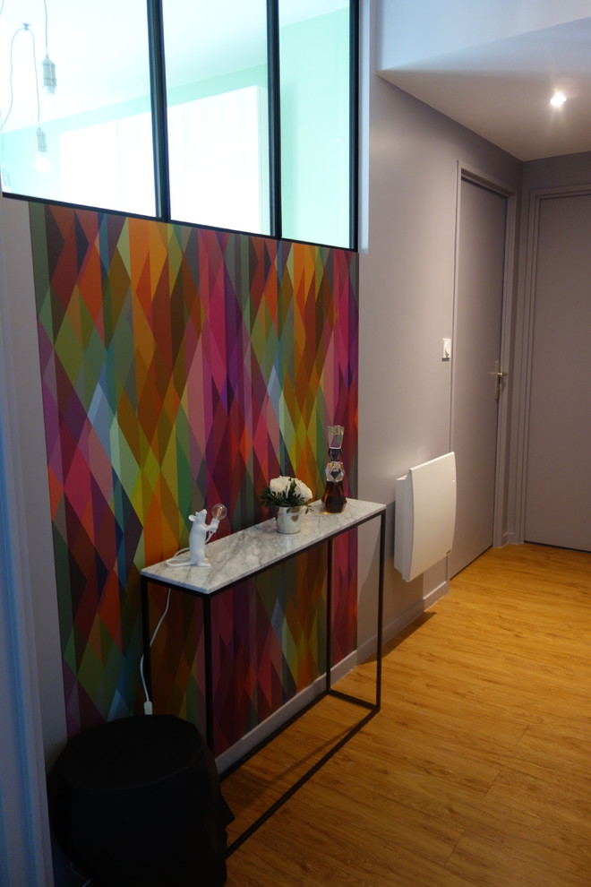 Esempio di un piccolo corridoio design con parquet chiaro, pareti multicolore, una porta singola, una porta grigia e pavimento multicolore