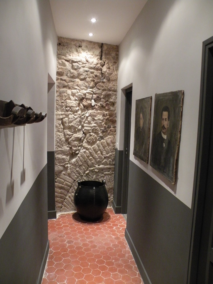 This is an example of a small contemporary foyer in Nice with black walls, terracotta flooring, a single front door, a medium wood front door and red floors.