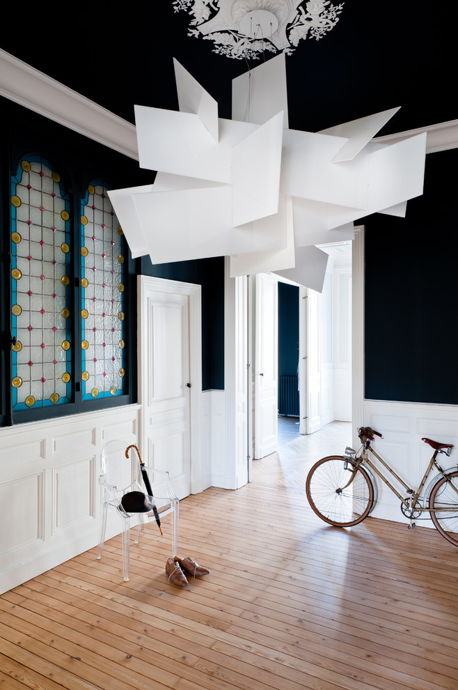 Inspiration pour un grand hall d'entrée design avec un mur bleu, parquet clair, une porte simple, une porte blanche et un sol marron.