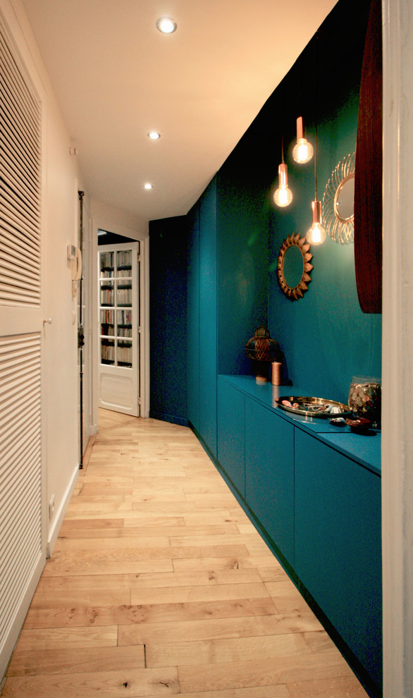Mid-sized trendy light wood floor entry hall photo in Paris with blue walls