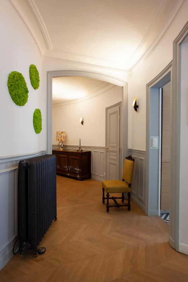 Großer Moderner Eingang mit grauer Wandfarbe, braunem Holzboden, Doppeltür, grauer Haustür und vertäfelten Wänden in Paris