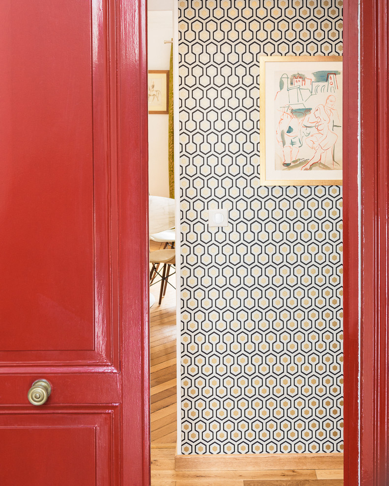 Immagine di un piccolo ingresso design con pareti multicolore, pavimento in legno massello medio, una porta a due ante e una porta rossa