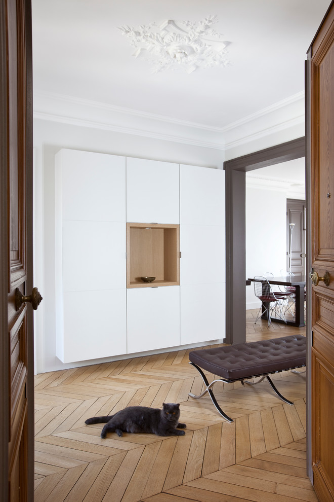Imagen de distribuidor contemporáneo grande con paredes blancas, suelo de madera en tonos medios, puerta doble y puerta de madera en tonos medios