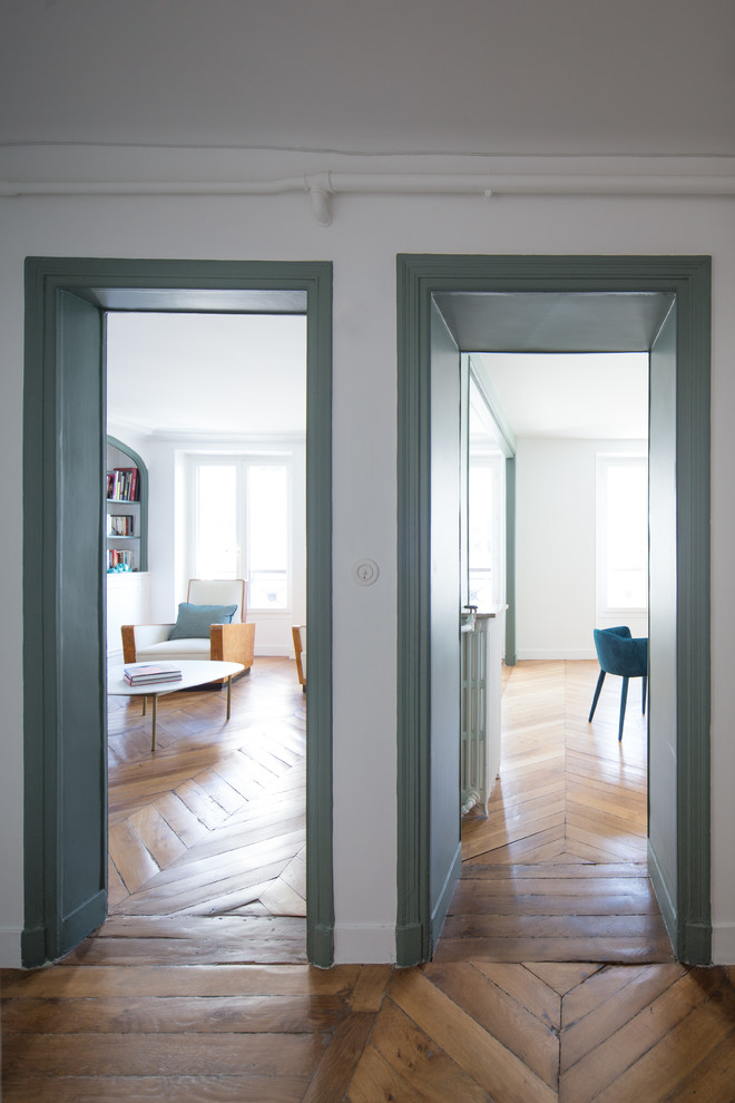 Großes Foyer mit grüner Wandfarbe, braunem Holzboden und braunem Boden in Paris