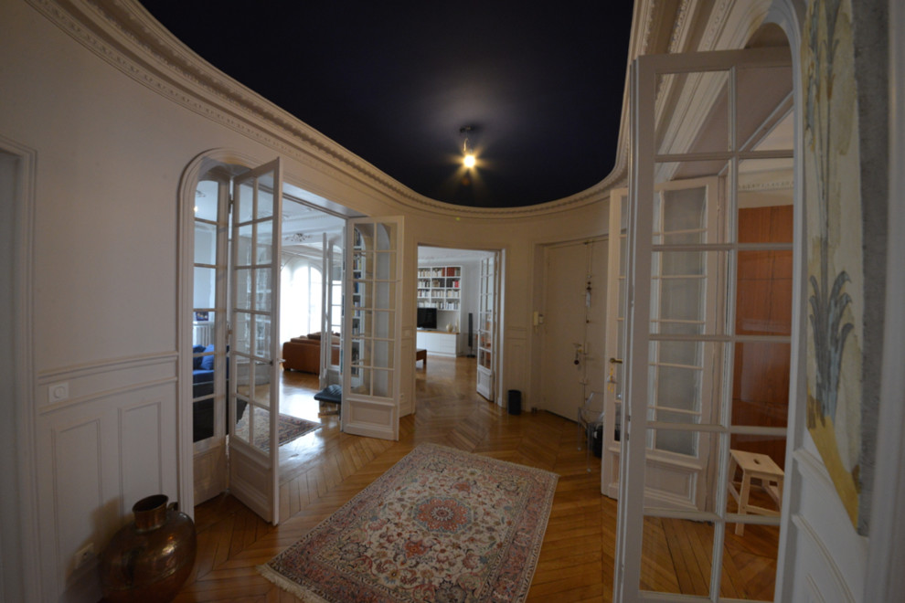 Großes Klassisches Foyer mit hellem Holzboden und Doppeltür in Paris