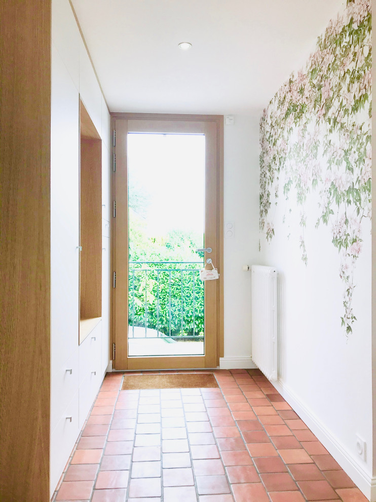 Kleines Klassisches Foyer mit weißer Wandfarbe, Terrakottaboden, Einzeltür, heller Holzhaustür, rotem Boden und Tapetenwänden in Nantes