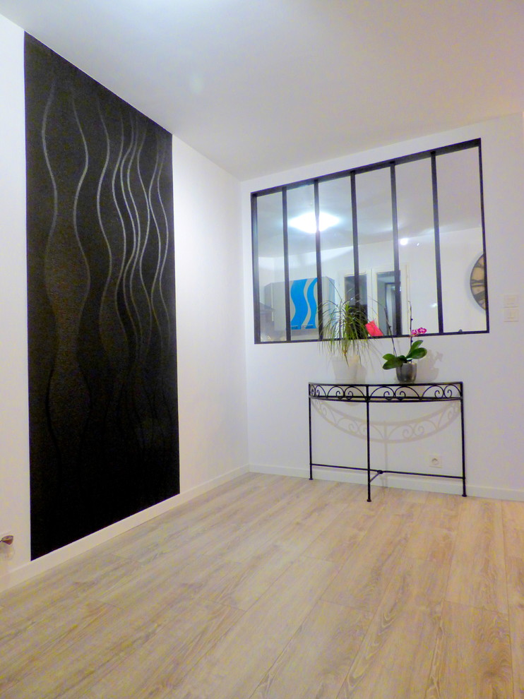 Источник вдохновения для домашнего уюта: большое фойе в стиле модернизм с черными стенами, полом из ламината и серым полом