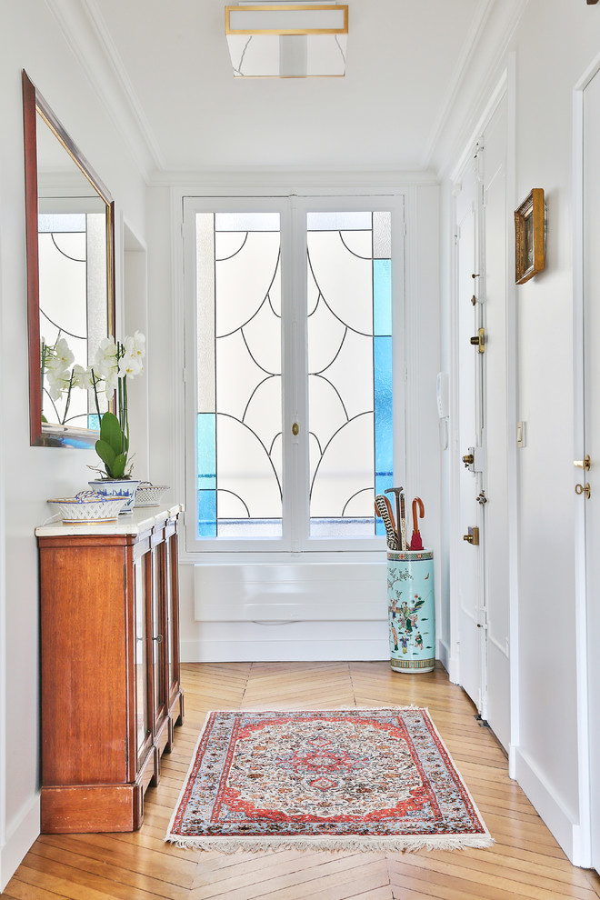 Immagine di un ingresso chic di medie dimensioni con pareti bianche, pavimento in legno massello medio, pavimento beige, una porta a due ante e una porta bianca