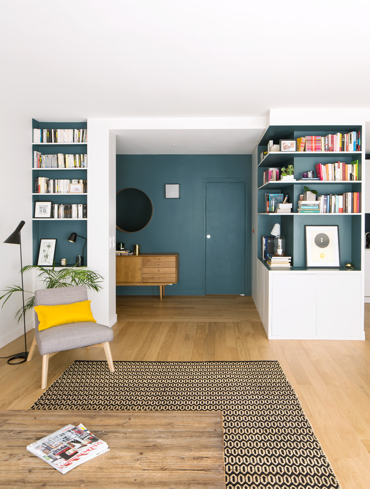Imagen de distribuidor actual de tamaño medio con paredes azules, suelo de madera clara, puerta simple, puerta azul y suelo beige