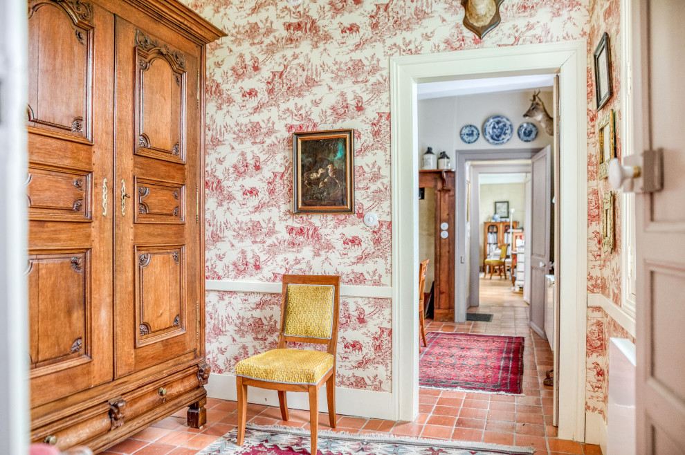 Источник вдохновения для домашнего уюта: узкая прихожая среднего размера в стиле кантри с красными стенами, полом из терракотовой плитки, одностворчатой входной дверью, белой входной дверью и оранжевым полом