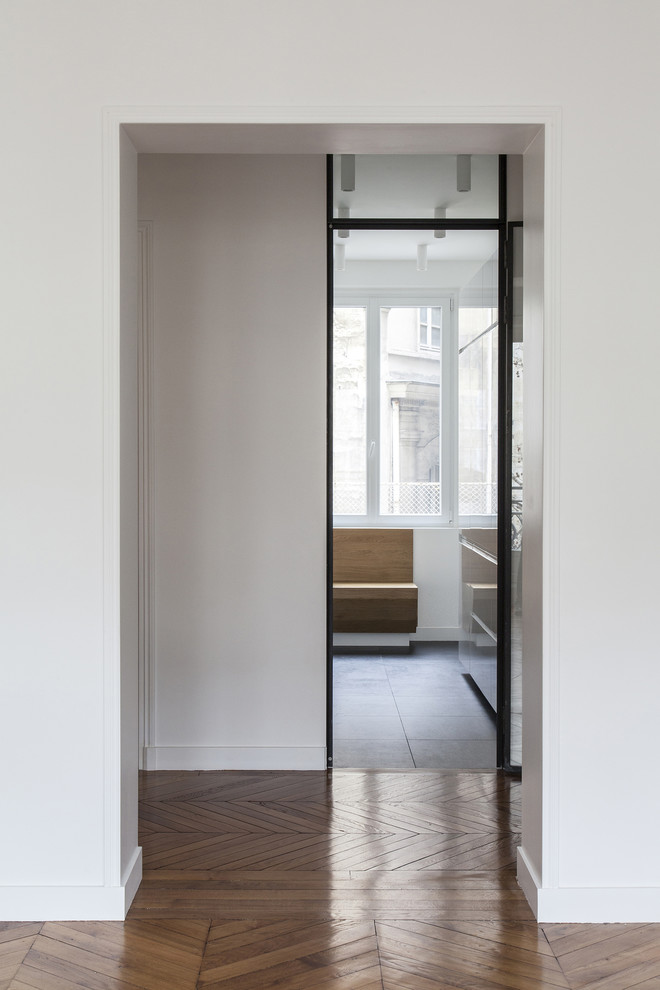 Inspiration for a large contemporary light wood floor entryway remodel in Paris with white walls and a white front door
