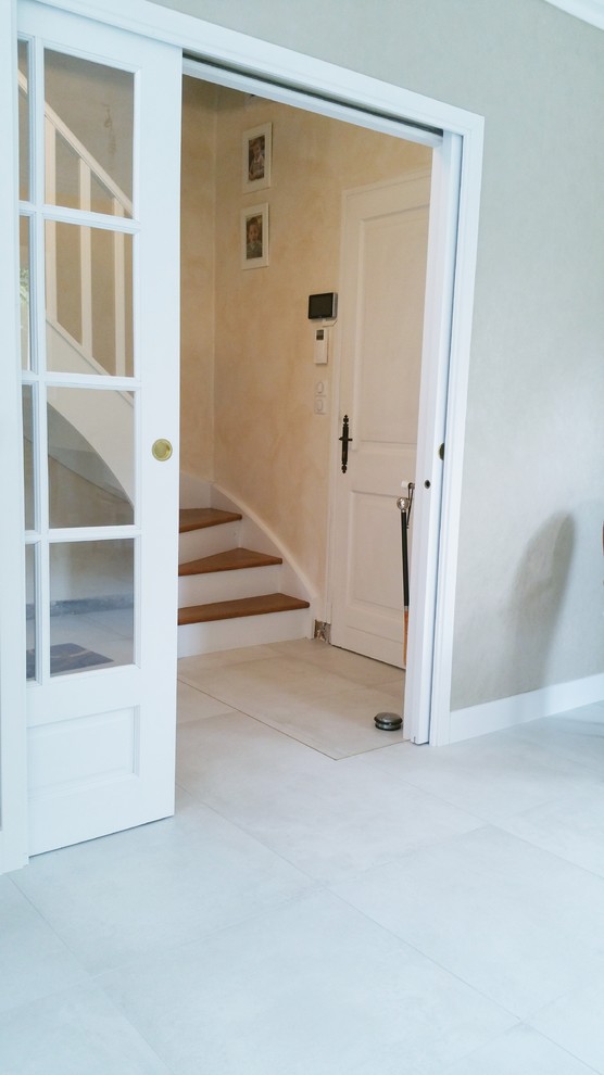 他の地域にある高級な中くらいなトランジショナルスタイルのおしゃれな玄関ロビー (ベージュの壁、セラミックタイルの床、白いドア、白い床) の写真