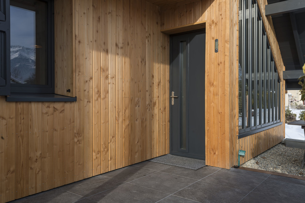 Idée de décoration pour une porte d'entrée nordique de taille moyenne avec une porte simple et une porte en bois foncé.