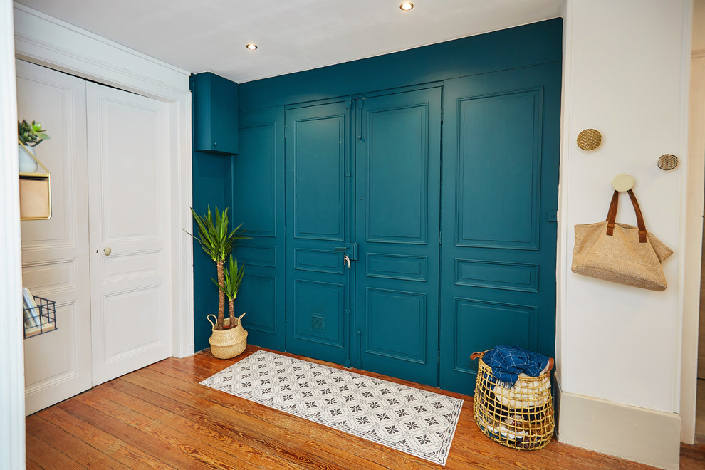 他の地域にあるモダンスタイルのおしゃれな玄関 (青い壁、濃色無垢フローリング) の写真