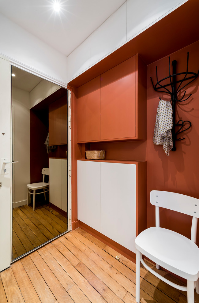 Medium sized urban foyer in Marseille with red walls, light hardwood flooring and a single front door.