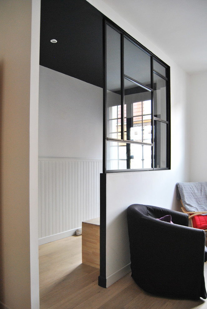 Inspiration för små minimalistiska hallar, med svarta väggar, ljust trägolv, en enkeldörr och beiget golv