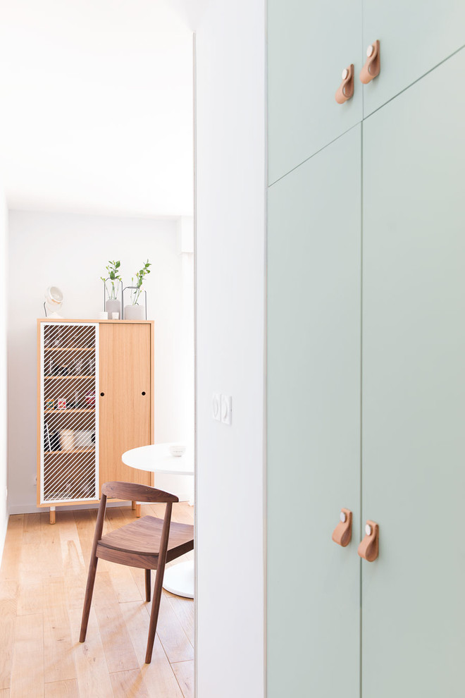 Cette photo montre une petite entrée tendance avec un couloir, un mur gris, parquet clair et une porte simple.