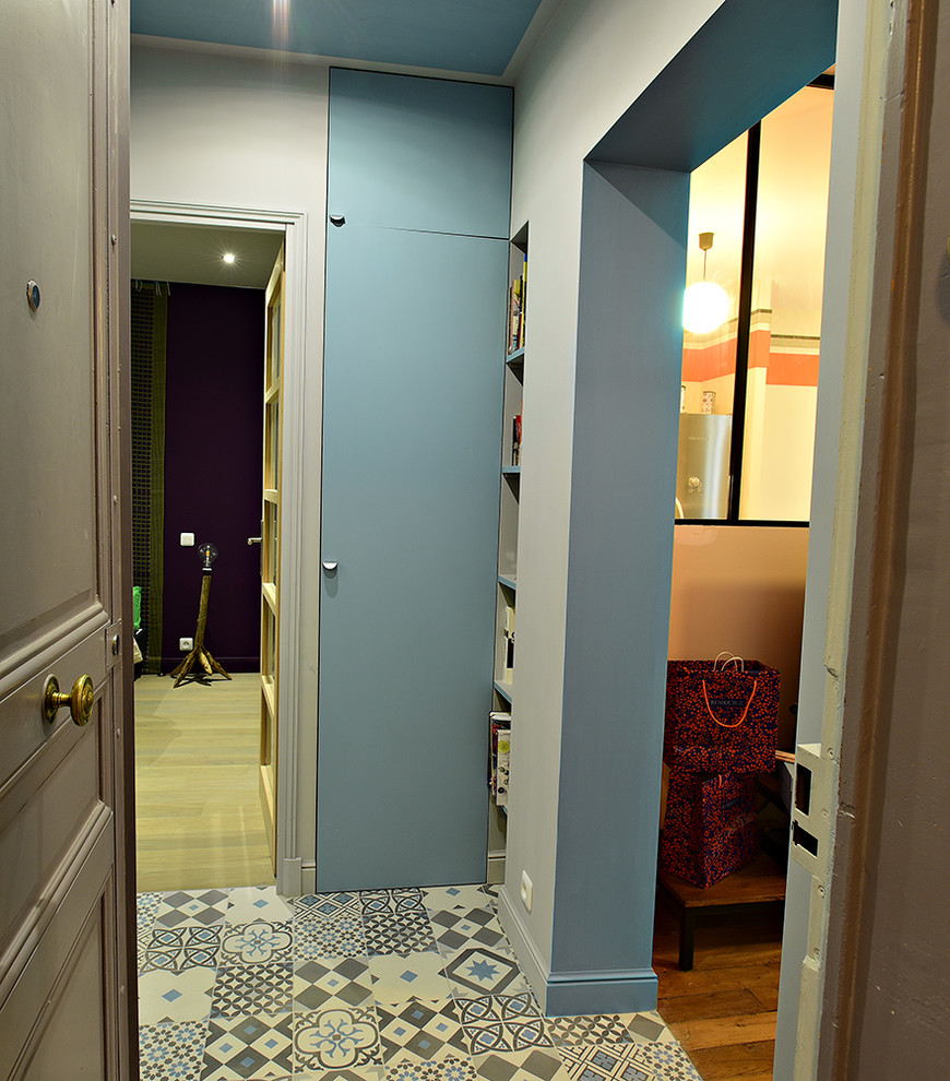 Foto på en liten funkis ingång och ytterdörr, med blå väggar, klinkergolv i keramik, en enkeldörr, en brun dörr och blått golv