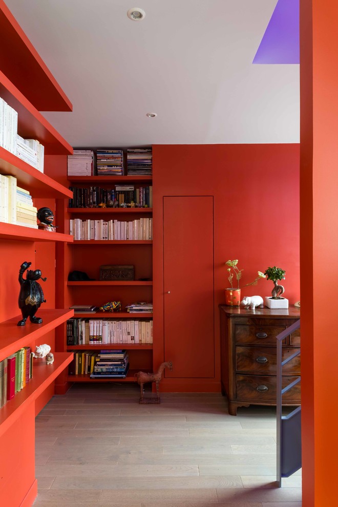 Exemple d'un très grand vestibule tendance avec un mur orange, parquet clair et une porte simple.