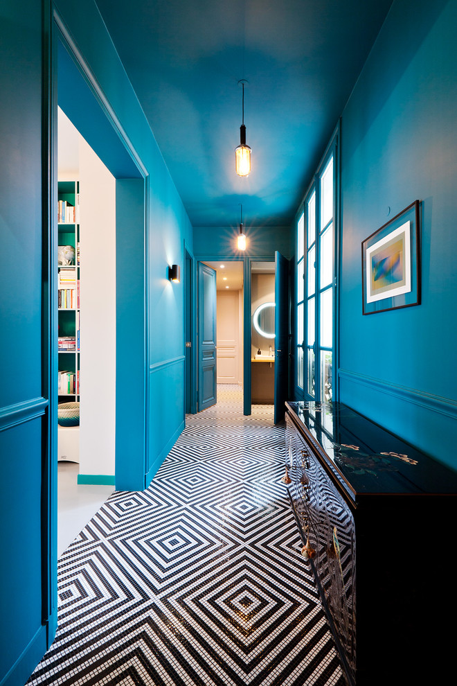パリにあるお手頃価格の中くらいなエクレクティックスタイルのおしゃれな玄関ホール (青い壁、黒い床、セラミックタイルの床) の写真