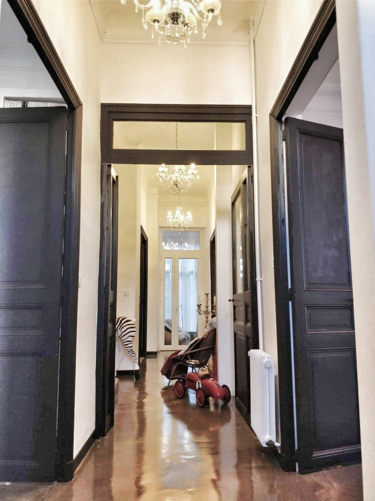 Large transitional concrete floor and gray floor entryway photo in Marseille with white walls and a black front door