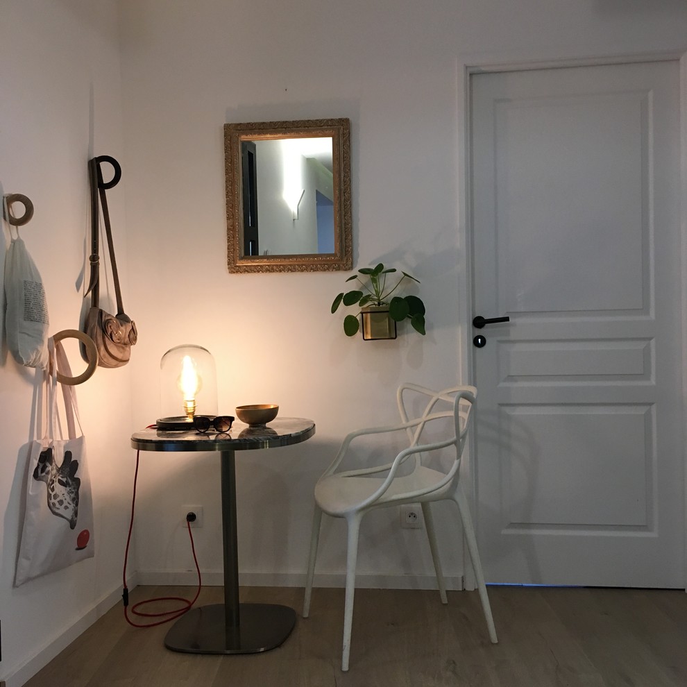 Photo of a contemporary entrance in Montpellier with white walls and light hardwood flooring.