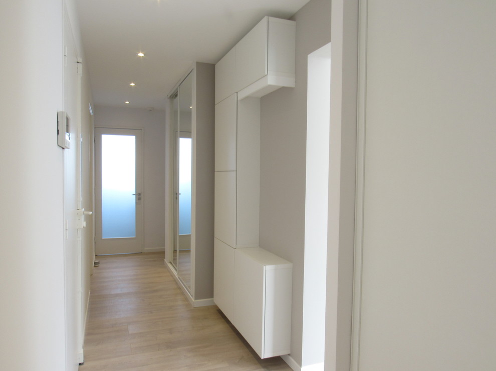 Idee per un grande ingresso minimal con pareti beige, parquet chiaro, una porta singola e una porta bianca