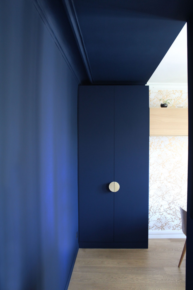 Idee per un corridoio classico con pareti blu, parquet chiaro e una porta blu
