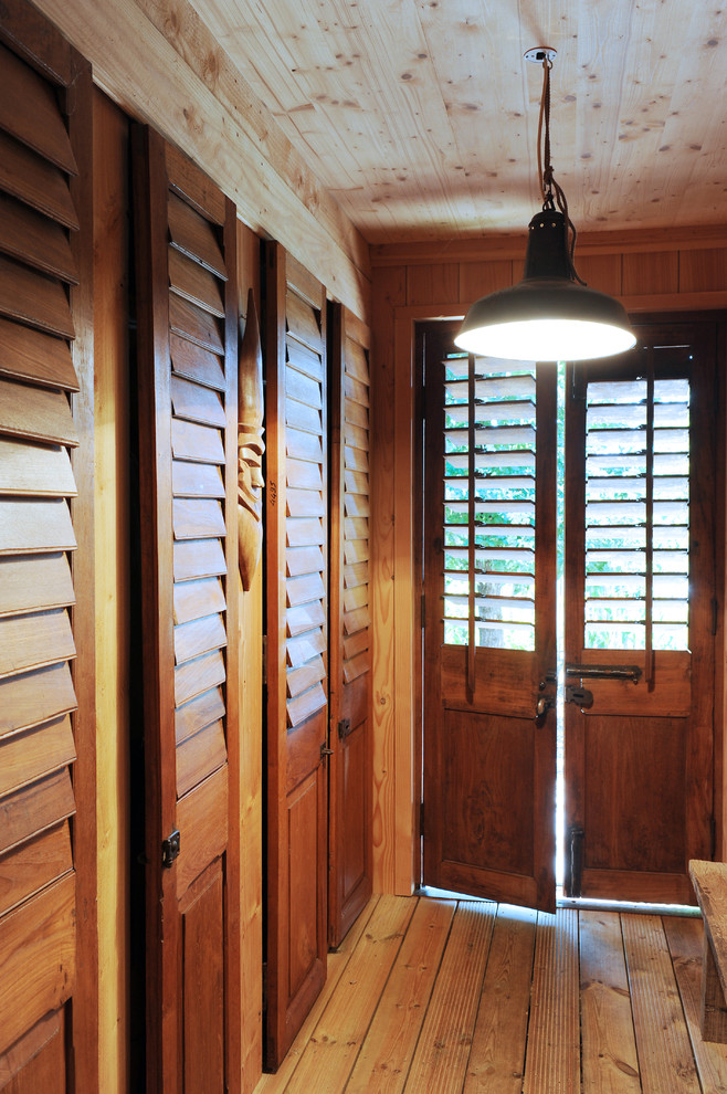Inspiration pour une entrée rustique de taille moyenne avec un vestiaire, un sol en bois brun, une porte double et une porte en bois brun.