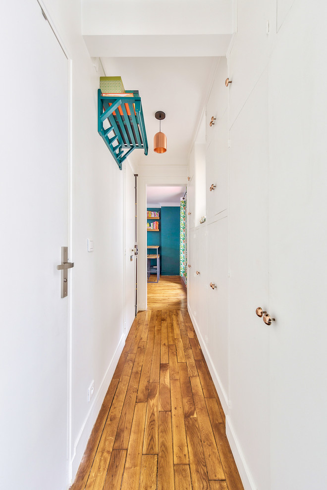Mid-sized trendy medium tone wood floor and brown floor entryway photo in Paris with white walls and a white front door