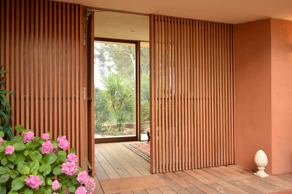 Idée de décoration pour une grande porte d'entrée asiatique avec un sol en bois brun et une porte simple.