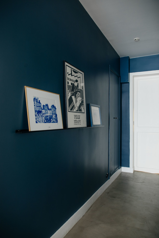 Ispirazione per un ingresso contemporaneo di medie dimensioni con pareti blu, pavimento in cemento e pavimento grigio