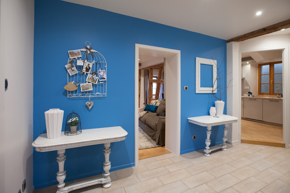 На фото: большое фойе в стиле шебби-шик с синими стенами, полом из керамической плитки и бежевым полом с