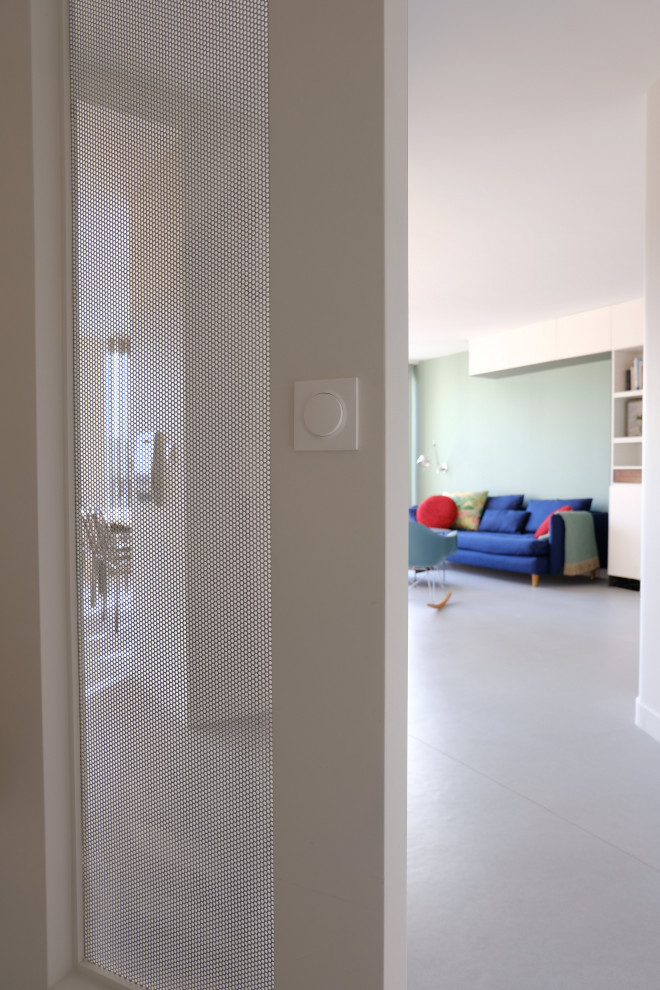 Modern inredning av en liten foajé, med beige väggar, linoleumgolv, en vit dörr och grått golv