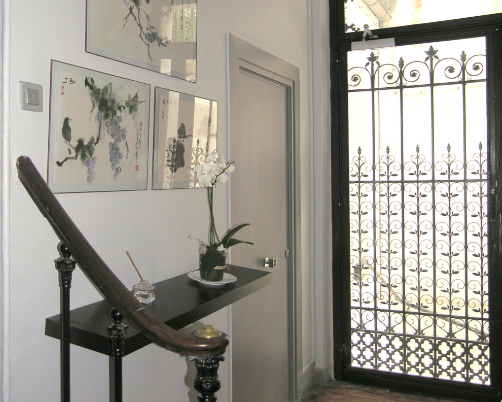 Design ideas for a traditional entrance in Paris with grey walls, medium hardwood flooring, a single front door and a black front door.
